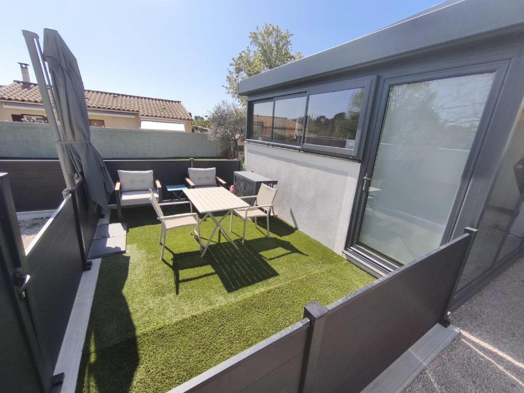 eine kleine Terrasse mit Tisch und Stühlen auf einem Balkon in der Unterkunft Charmant Studio in La Motte-dʼAigues