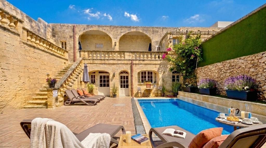 a courtyard with a swimming pool in a building at Ta' Matmura Boutique B&B in Għarb