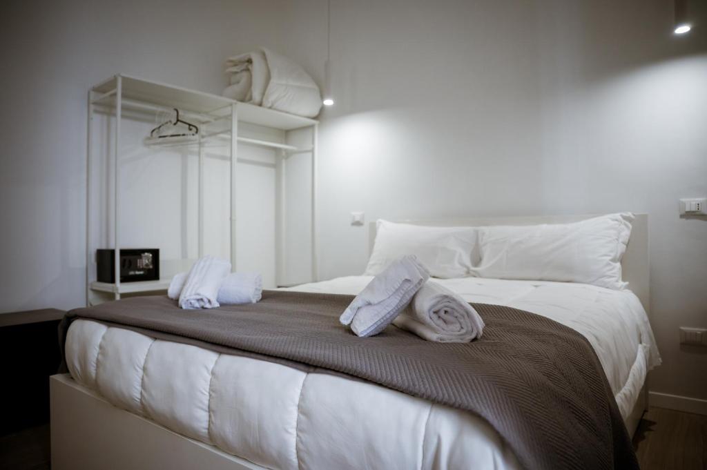 a large white bed with white pillows on it at dellarocca4 in Cefalù