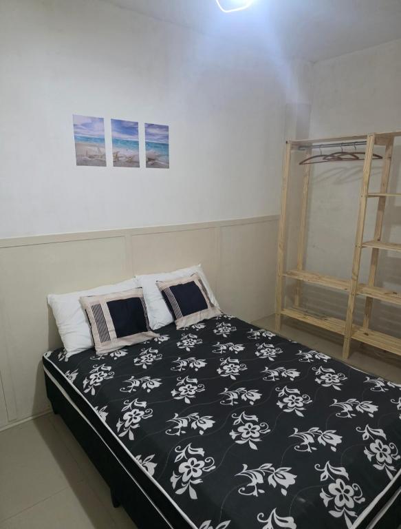 a bedroom with a black and white bed and a ladder at 30 metros do mar, 2 quartos! in Pontal do Paraná