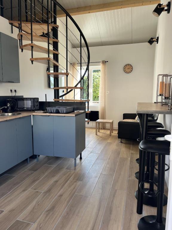 a kitchen with wooden floors and a spiral staircase at Chez Raphaël et Hiba in Nesles