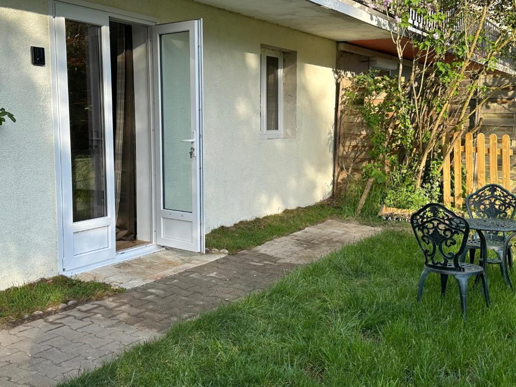 a table and chairs in the grass next to a house at Le Cerisier in Giverny