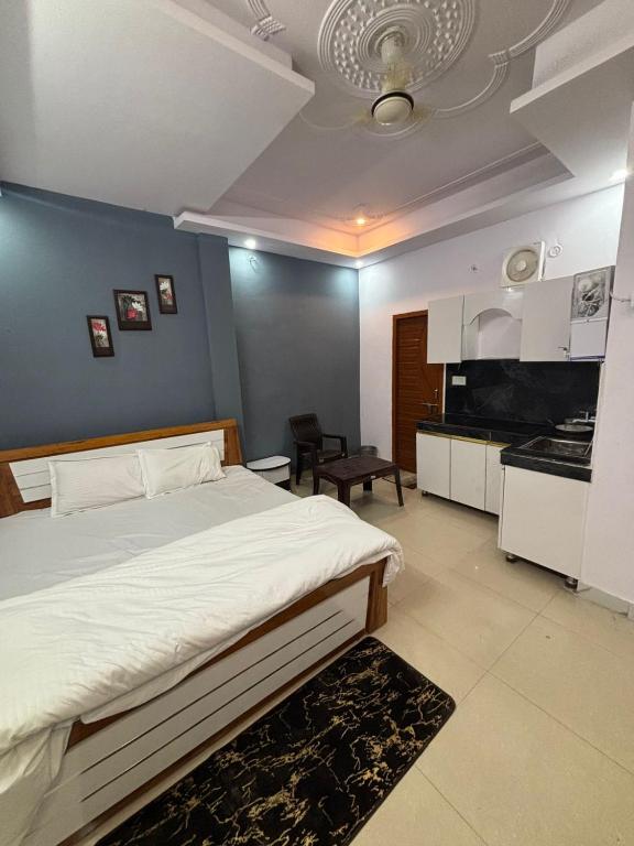 a bedroom with a large bed and a kitchen at Indigo Inn in Malhour