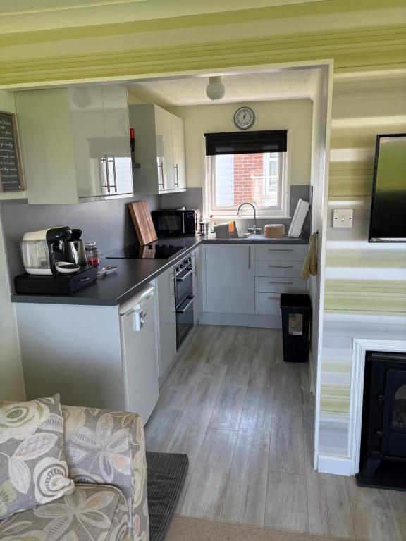 a kitchen with white cabinets and a counter top at Sally Chalet in Hemsby