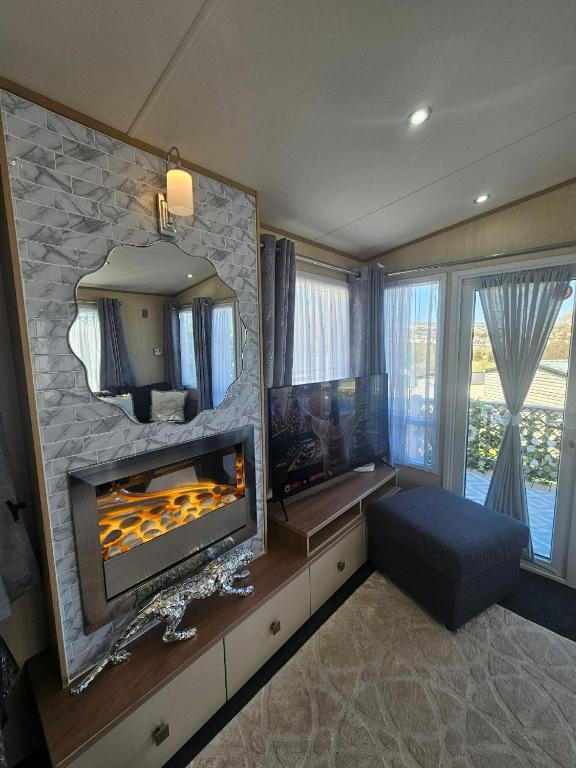 a living room with a fireplace and a large mirror at Luxury 3 bedroom caravan hobourne Devon bay with hot tub in Goodrington