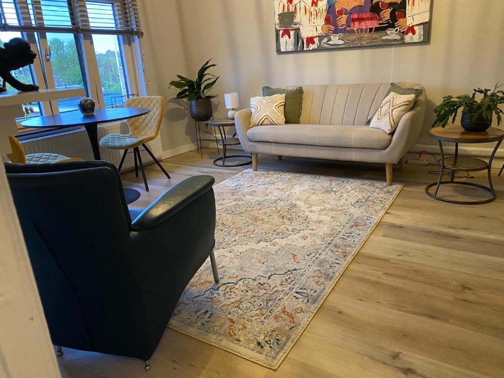 a living room with a couch and a table and chairs at B&B Pied à Pieter in Maastricht
