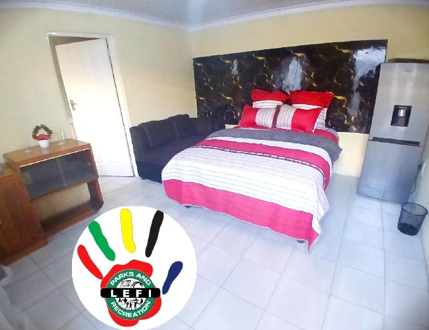 a bedroom with a bed with red and white at Lefi Recreational Park in Wolmaranstad