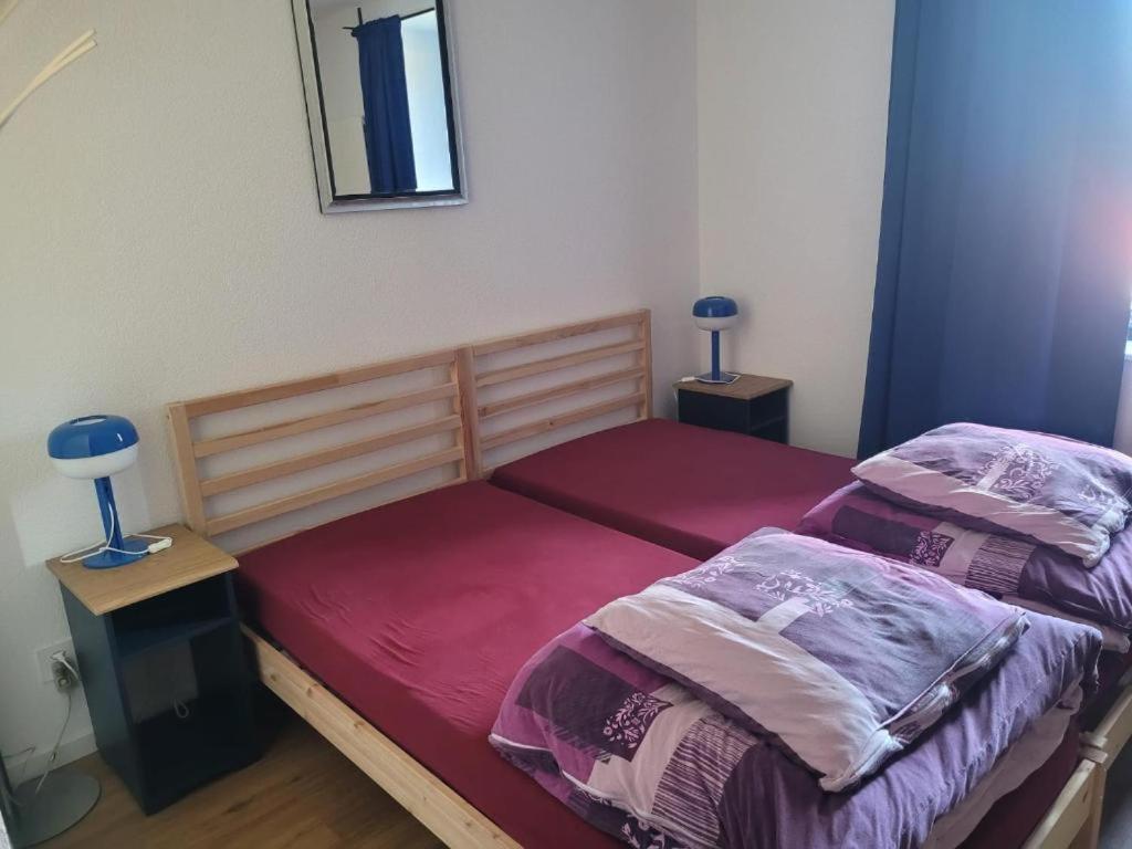 a bedroom with two beds and a mirror on the wall at Auberge des Fées in Buttes