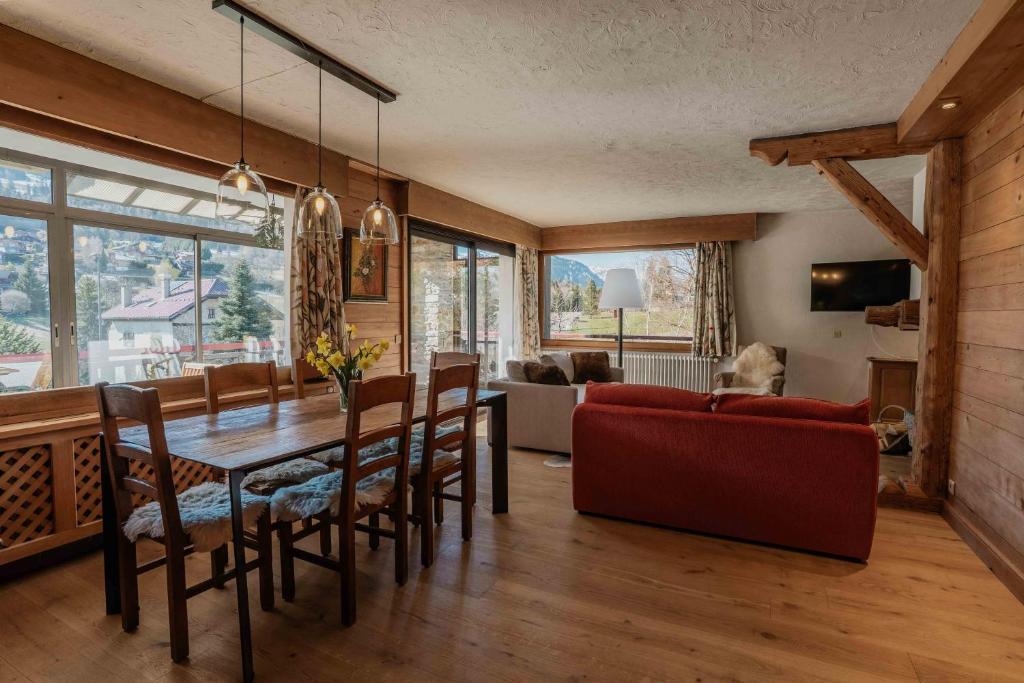 a living room with a table and a red couch at appartement 103m2 près de Megève, face à télécabine la Princesse,2 chambres , garage, local à ski in Demi-Quartier