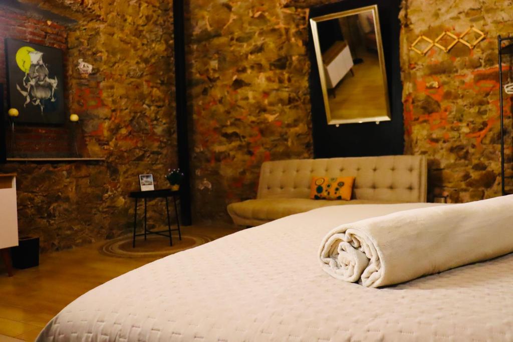 a bedroom with a bed and a stone wall at San Felipe Loft in Panama City