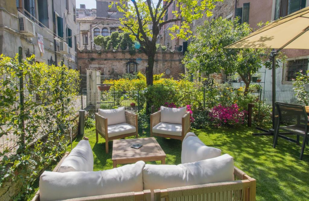 a patio with couches and a table and chairs at Ca' de l'Astrologo in Venice
