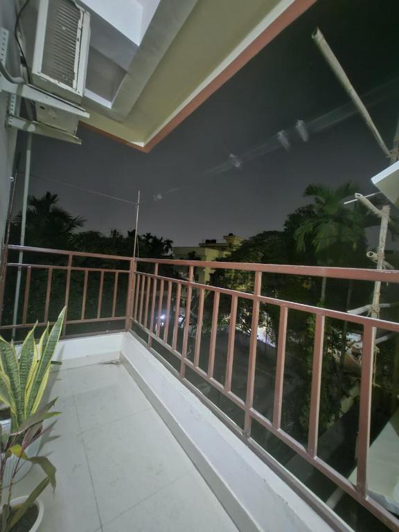a balcony with a view of the ocean at night at Pink villa inn in Guwahati