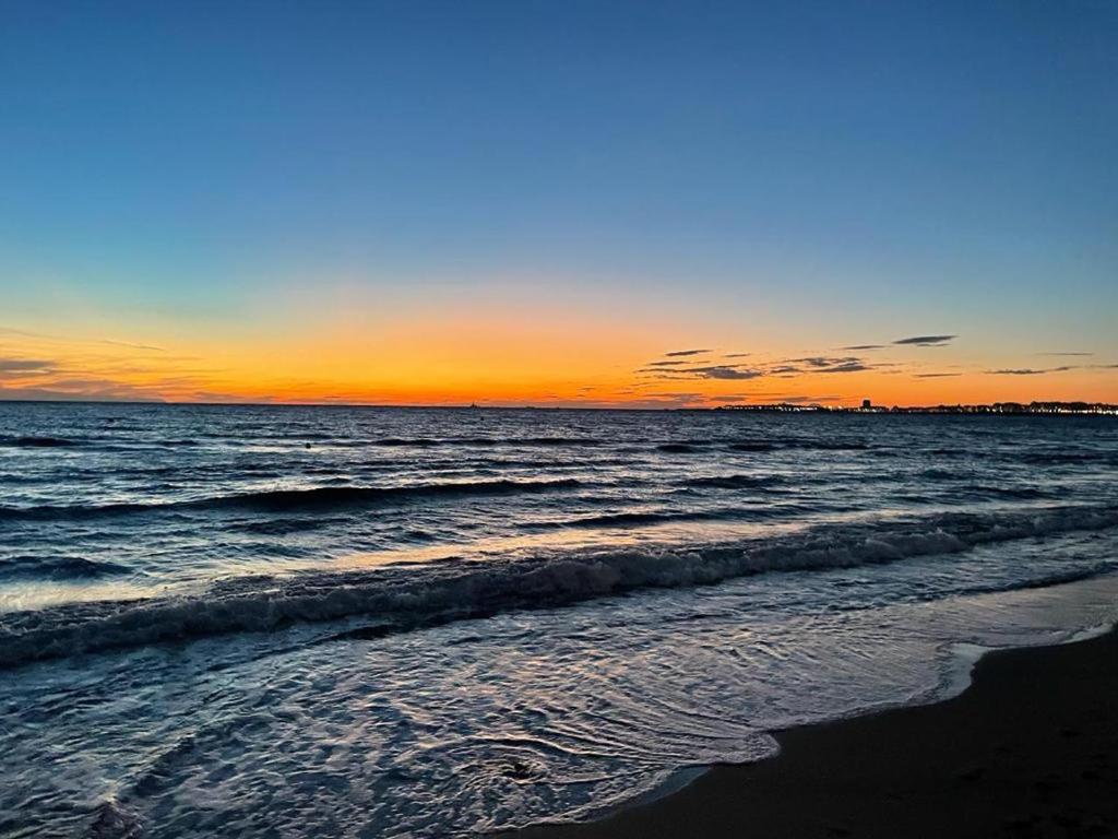 a sunset over the ocean with a beach with waves at tulip 59 in Gallipoli