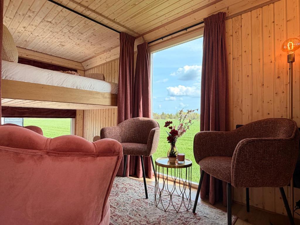 a bedroom with two chairs and a bunk bed at CRASH'NSTAY - Moppie Avenue in Hooge Vaart