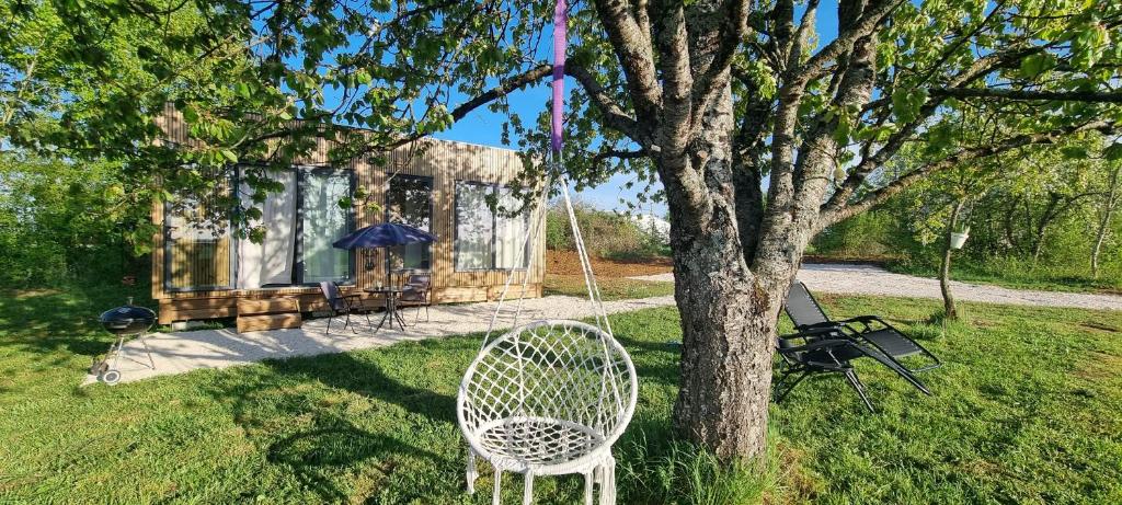 a swing hanging from a tree in front of a house at Gîte isolé avec terrasse in Laignes