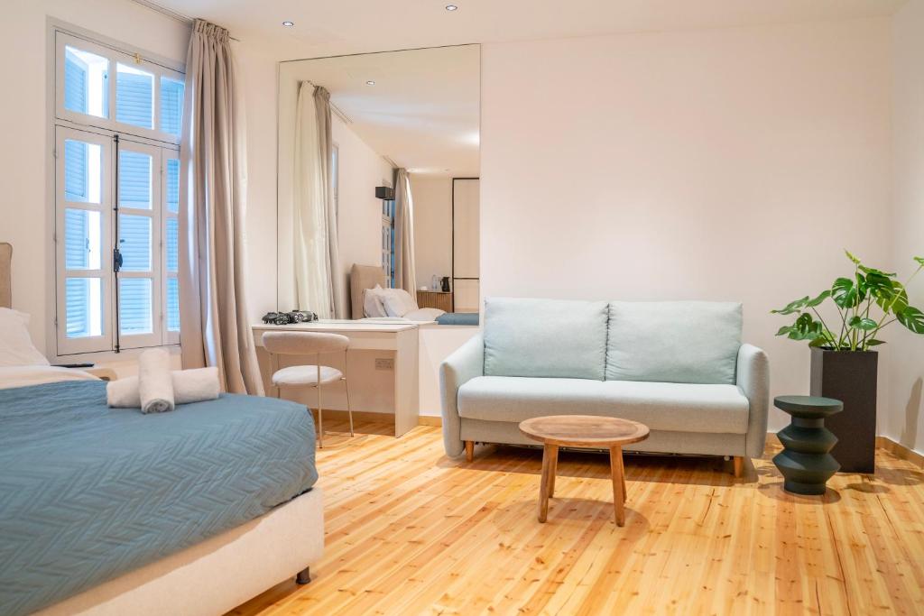 a bedroom with a bed and a couch and a table at Epos by the Sea in Larnaca