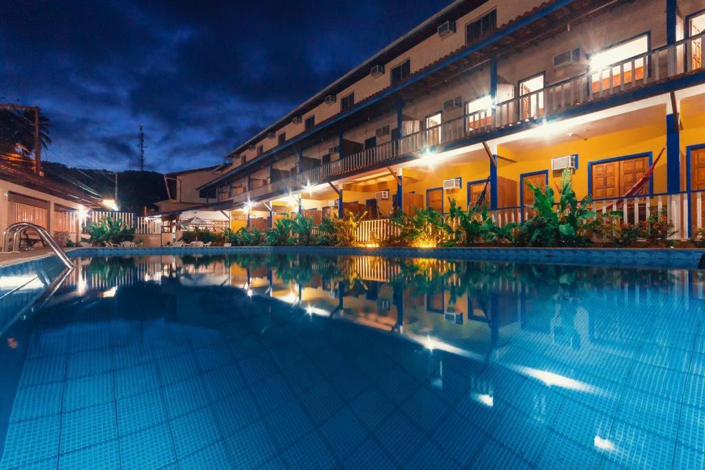 ein Schwimmbad vor einem Gebäude bei Nacht in der Unterkunft Morro da Saudade in Cayru