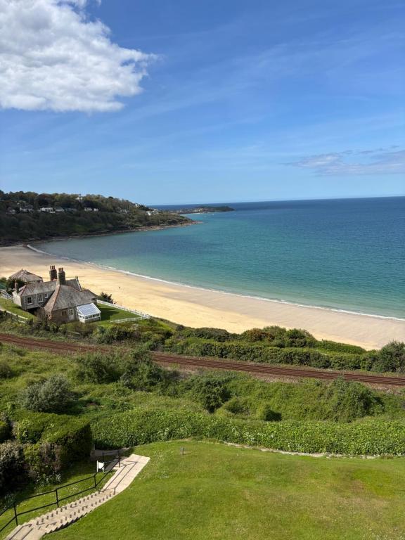 a view of a beach with a house and the ocean at Aigua Blava in Carbis Bay
