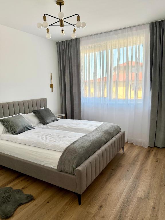 a bedroom with a large bed and a window at Emerald Stay in Şelimbăr