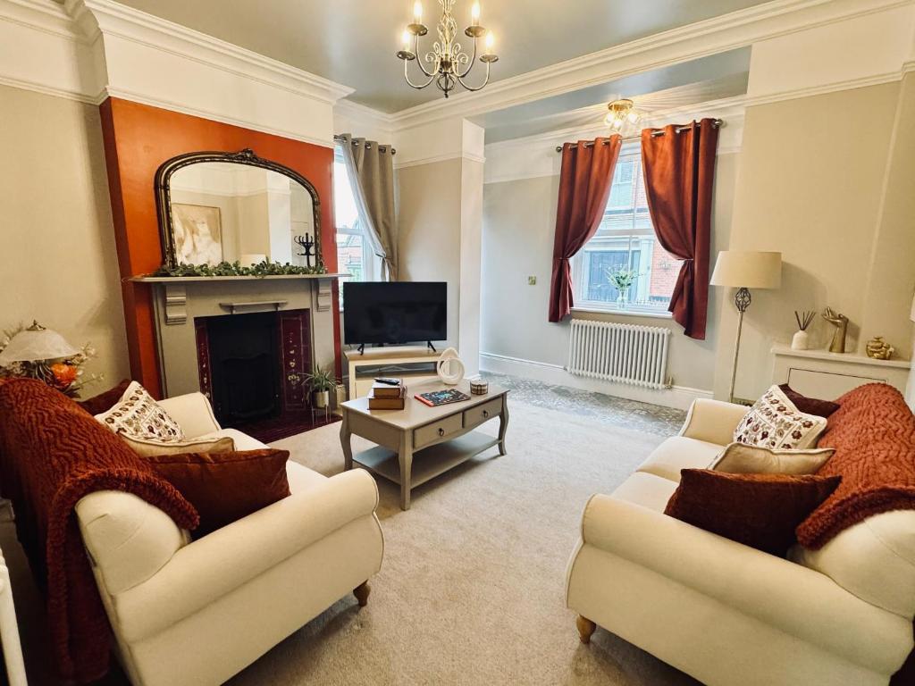a living room with two couches and a tv at Moody House in Congleton