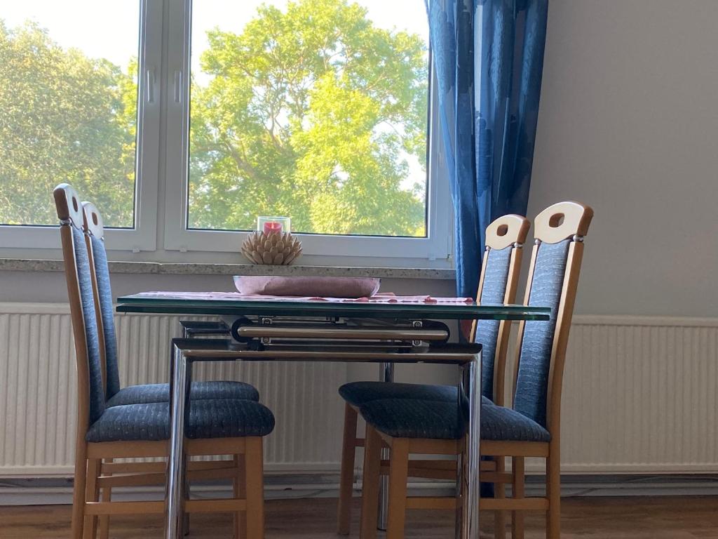 a dining room table with four chairs and a window at Ferienwohnung in Ostseenähe 1 in Velgast