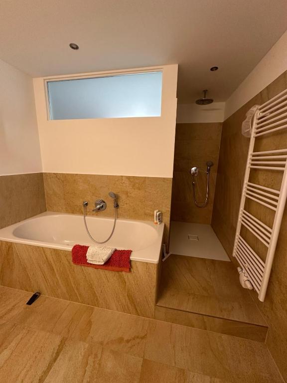 a bathroom with a bath tub and a window at Ferienwohnung am Warnowhang in Kessin