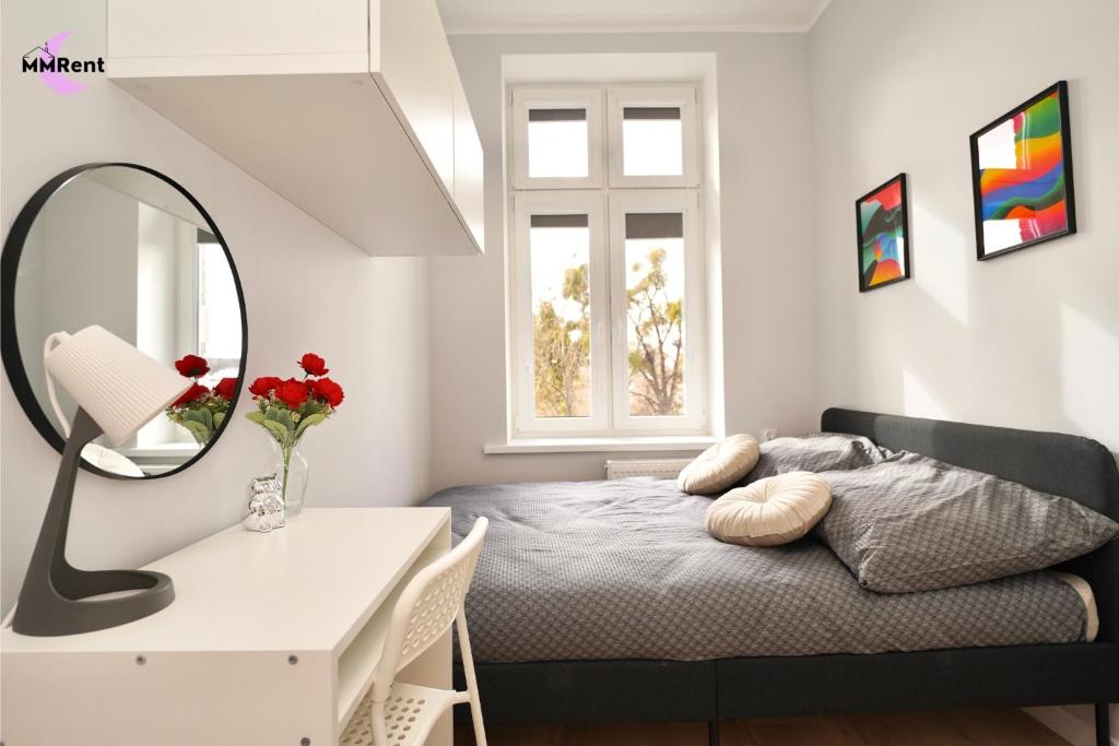 a bedroom with a bed and a mirror and a desk at MMRent Colorful Room in Gdańsk