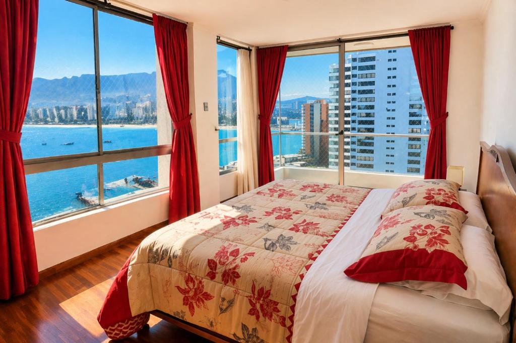a bedroom with a bed and large windows at Departamentos Nautilus in Iquique