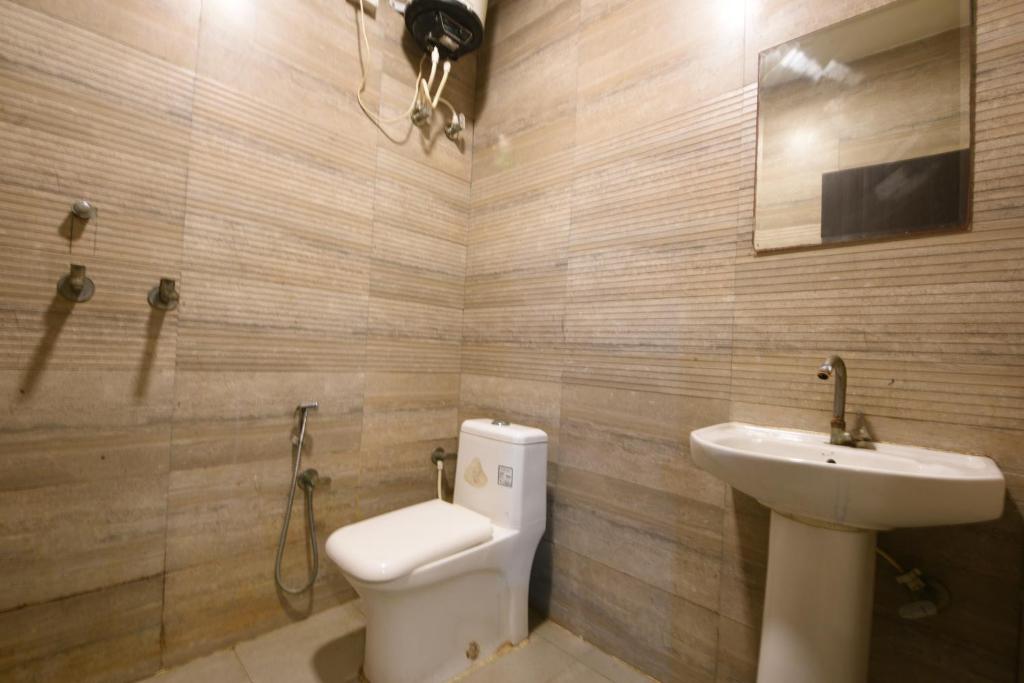 a bathroom with a toilet and a sink at Hotel Stay 21 in Faridabad