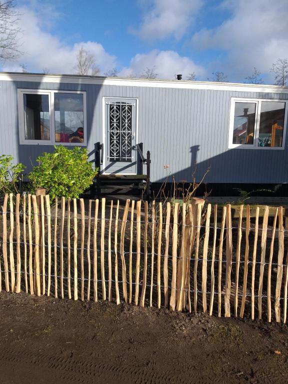 a house is shown behind a fence at Woonwagen Carpe Diem in Oudwoude