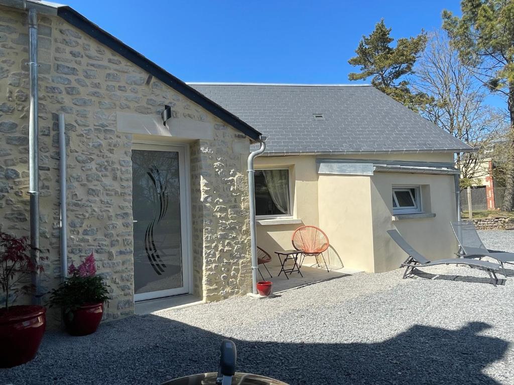 a house with a door and a chair in front of it at Au petit lavoir in Trévières