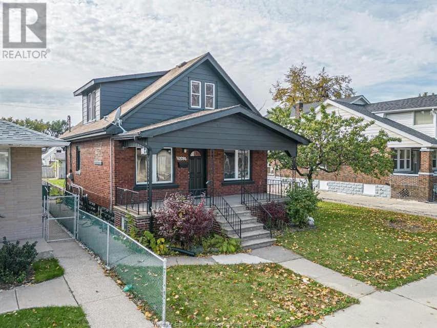 a brick house with a fence in front of it at Black door bungalow in Windsor