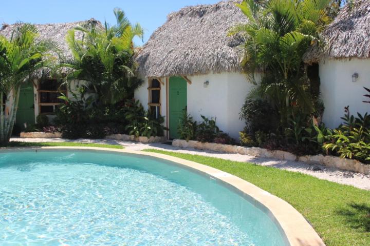 a resort with a swimming pool in front of a building at Hotel Kocai Izamal in Izamal