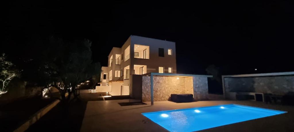 a swimming pool in front of a house at night at TAO House in Ferma