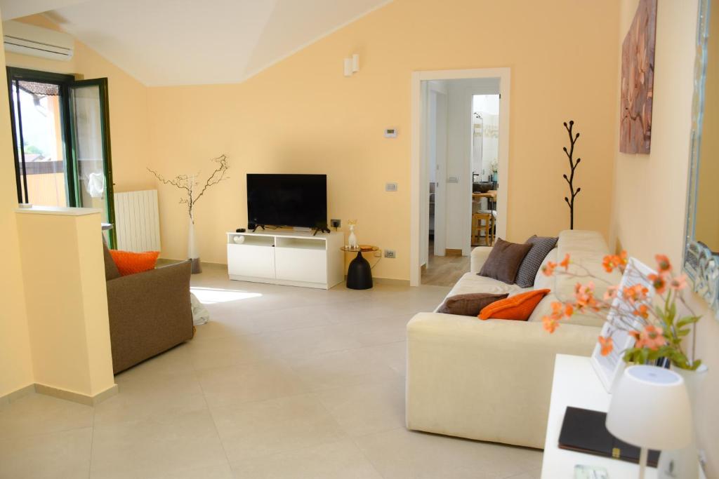 a living room with a couch and a tv at Casa Sole - holiday apartment in Maccagno Superiore