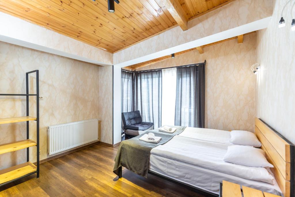 a bedroom with a bed and a chair in it at Mestia HOTEL AMIRANI in Mestia