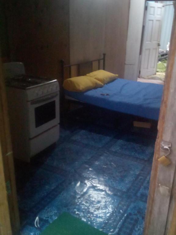 a small bedroom with a bed and a stove at Mabouya Villas in Dennery