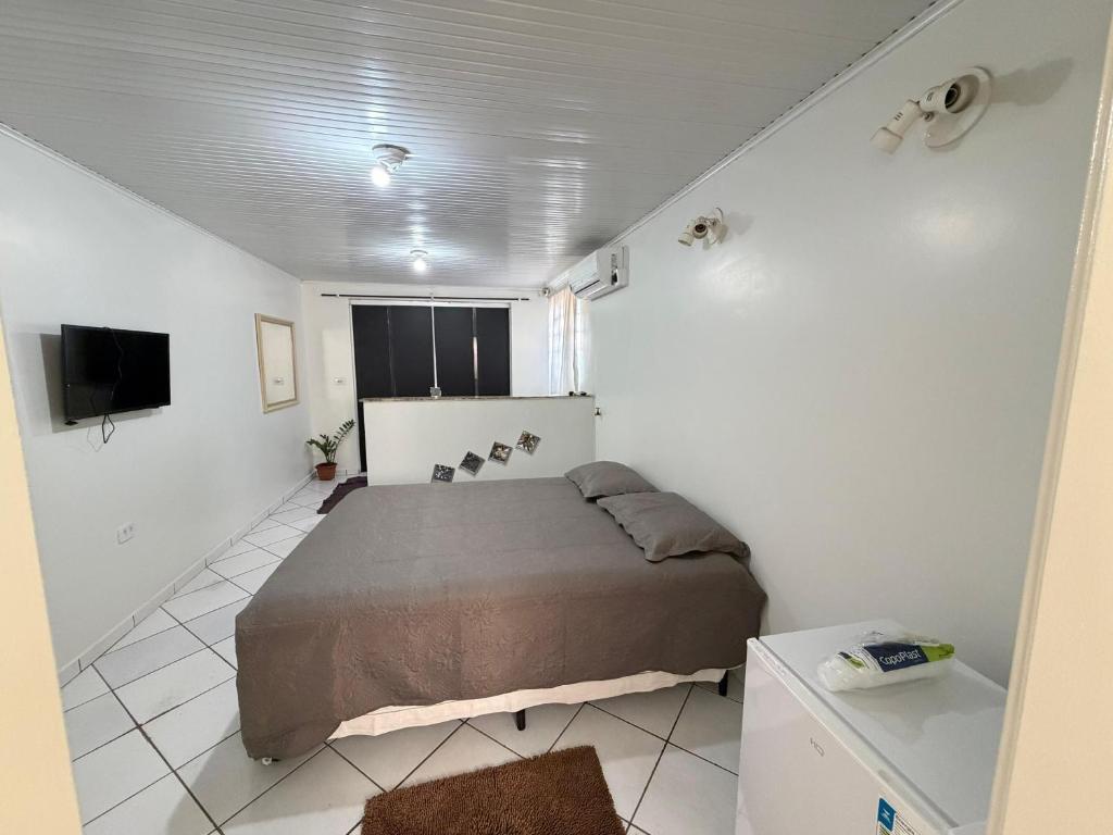a bedroom with a bed in a white room at Repouso Tranquilo in Assis