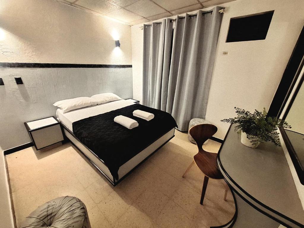 a small bedroom with a bed and a table at Santa lucia in Panama City