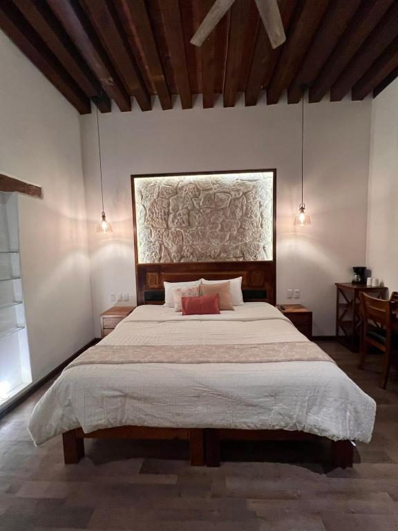 a bedroom with a large bed with two red pillows at Navarrete 63 Hotel in Morelia