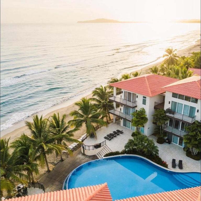 an aerial view of a resort with a pool and the beach at Apartamento Arrecife in Tela