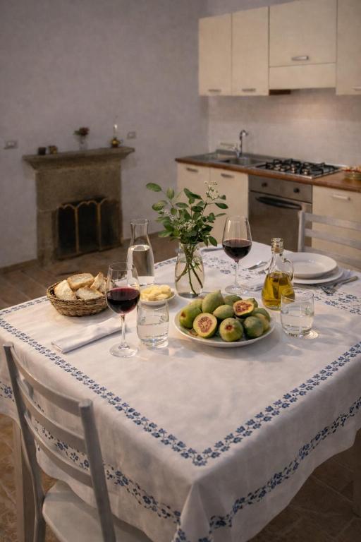 a table with a plate of fruit and wine glasses at Cilento House with Garden & Sunset View in Sessa Cilento