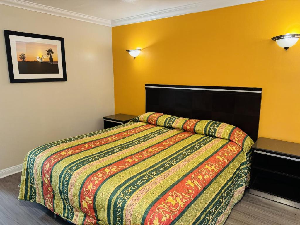 a bedroom with a bed with a colorful comforter at Imperial Inn & Suites in Norwalk