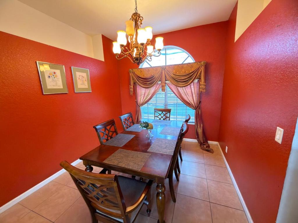 a dining room with a wooden table and a chandelier at Acreage Oasis - 5 Bedrooms, Pool, Space, Serenity in West Palm Beach