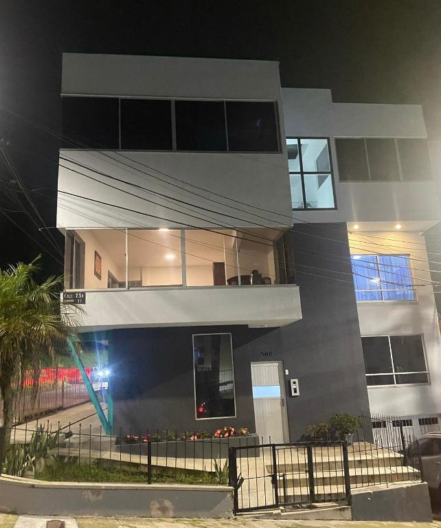 a tall building at night with a fence in front of it at Casa Aurora in Manizales
