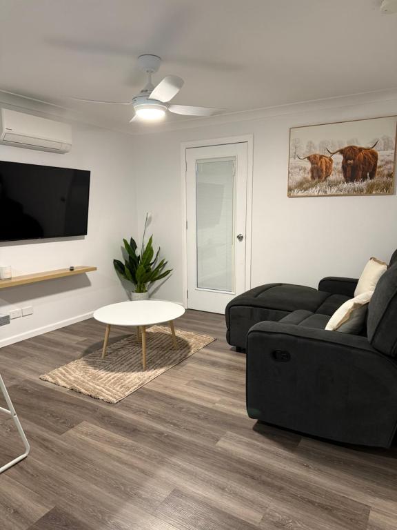 a living room with a black couch and a table at The Shed Bed & Breakfast in Hay