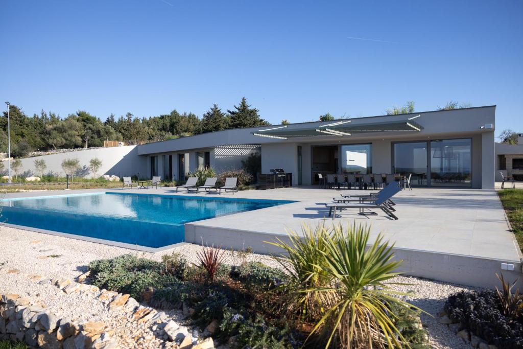 a house with a swimming pool in front of it at Kai House in Lun