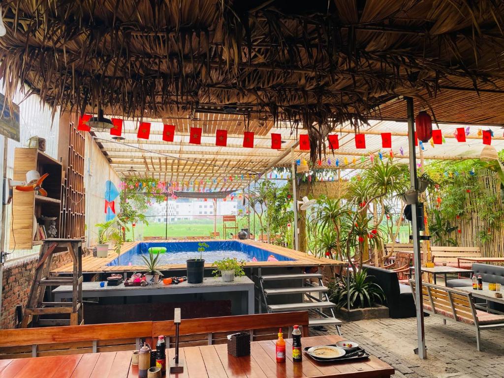 a restaurant with a swimming pool in the middle of it at Big J Hostel in Ninh Binh