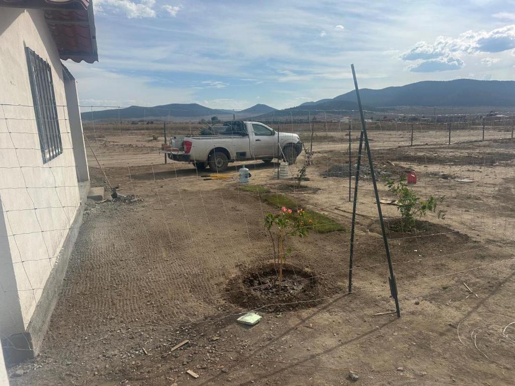 a truck parked in a field next to a house at Rancho Las Bugambilias in Arteaga