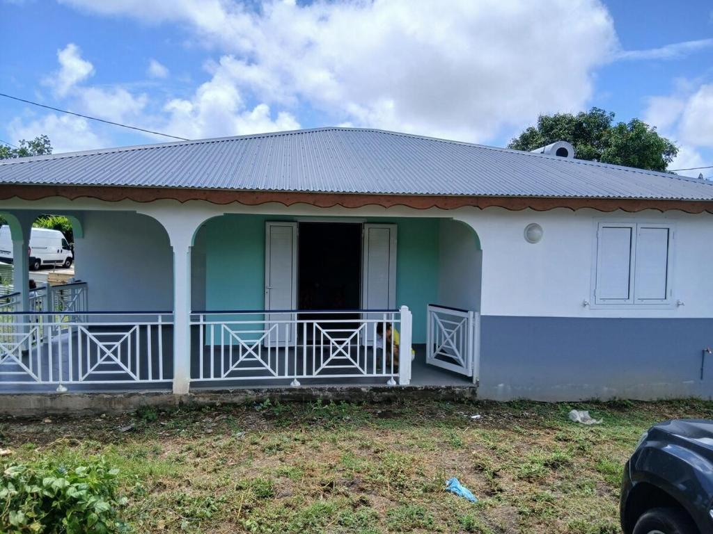 a small house with a green and white at Maison Hibiscus in Petit-Bourg